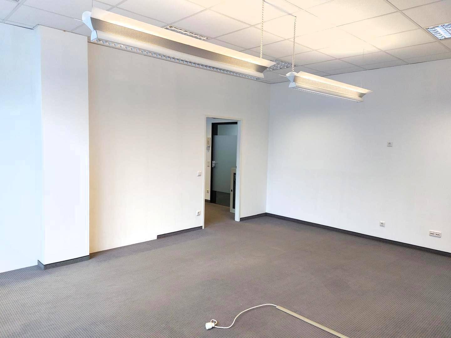 Geräumiger, leerer Büroraum mit Teppichboden und abgehängter Decke, bereit zur individuellen Gestaltung.
