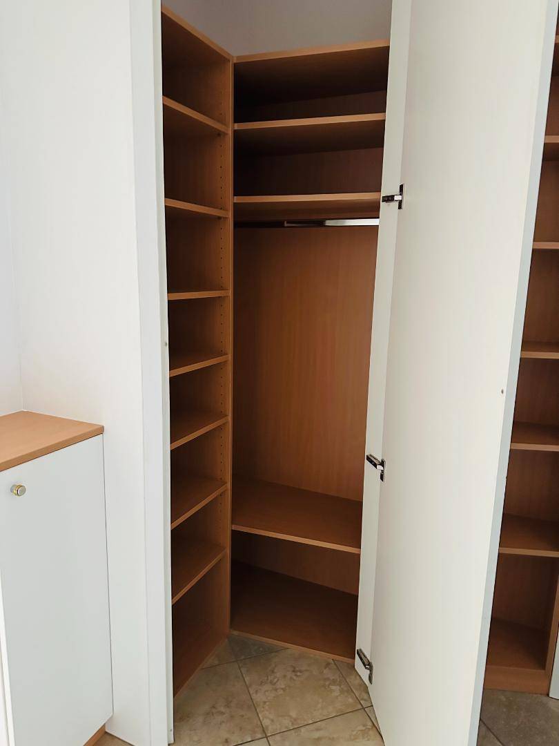 Offener Eck-Einbauschrank mit vielen Regalen und Kleiderstange, ideal für organisierte Aufbewahrung.