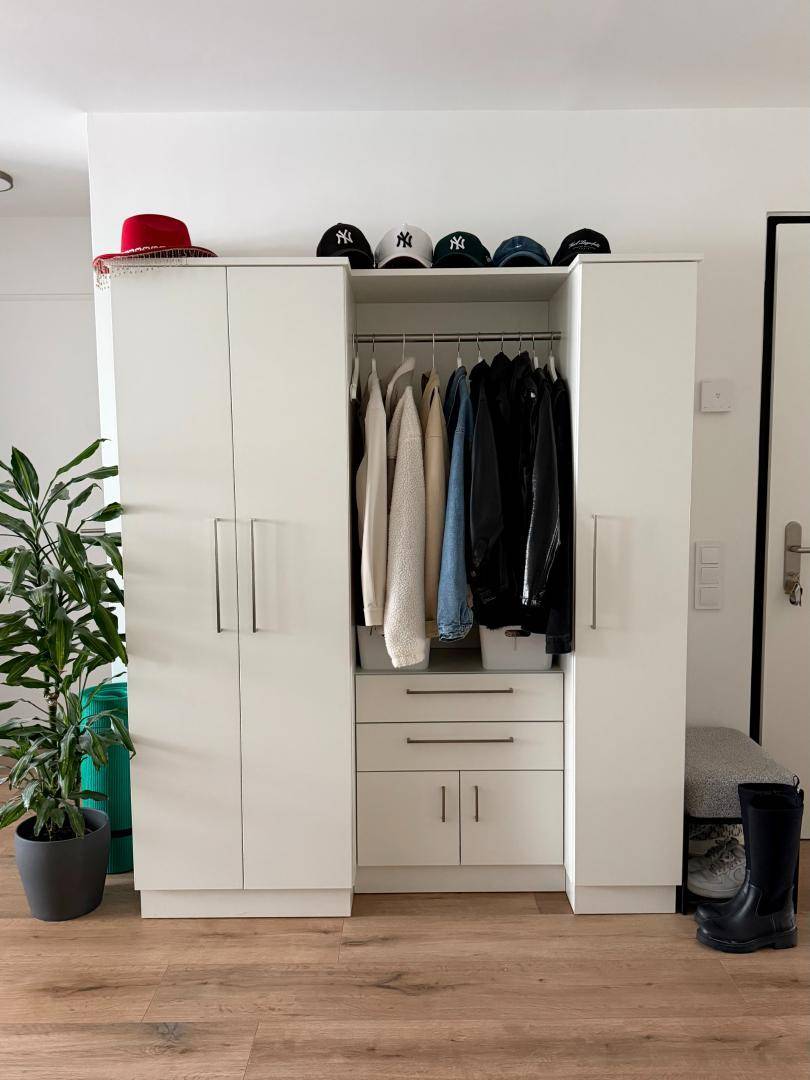 Heller Flur mit praktischem Garderobenschrank und Stauraum für Kleidung und Schuhe.