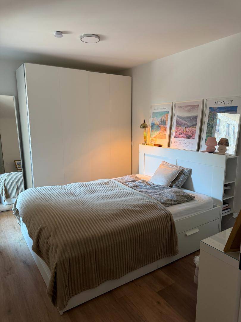 Gemütliches Schlafzimmer mit Doppelbett, Stauraum und moderner Dekoration.
