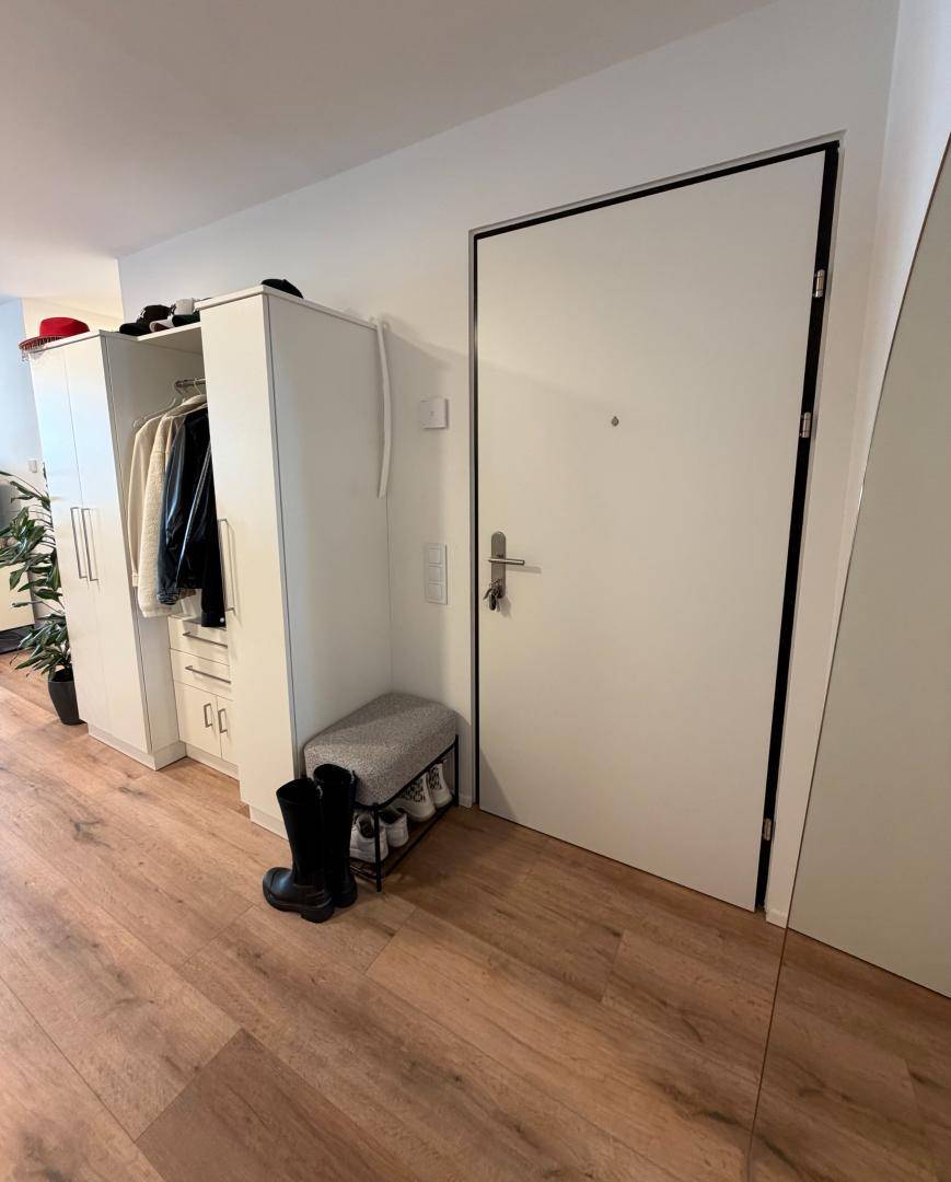 Eingangsbereich mit Garderobenschrank, Sitzbank und Laminatboden.