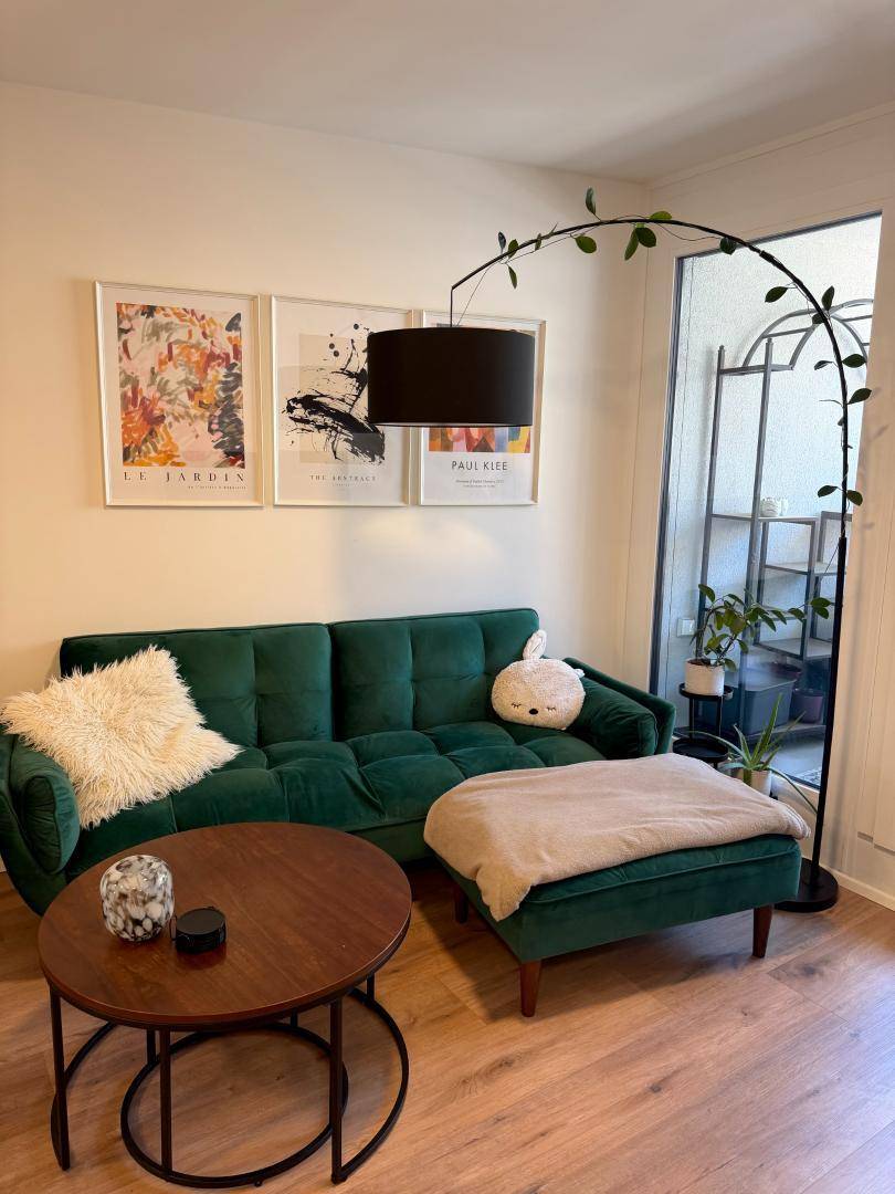 Modern eingerichtetes Wohnzimmer mit bequemem Sofa, Couchtisch und dekorativen Bildern.