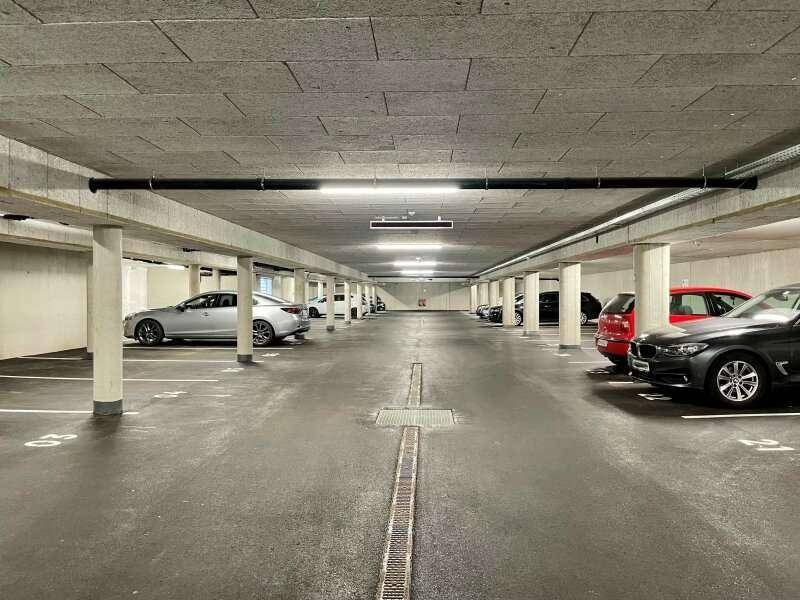 Geräumige Tiefgarage mit zahlreichen Stellplätzen, Betonpfeilern und guter Beleuchtung.