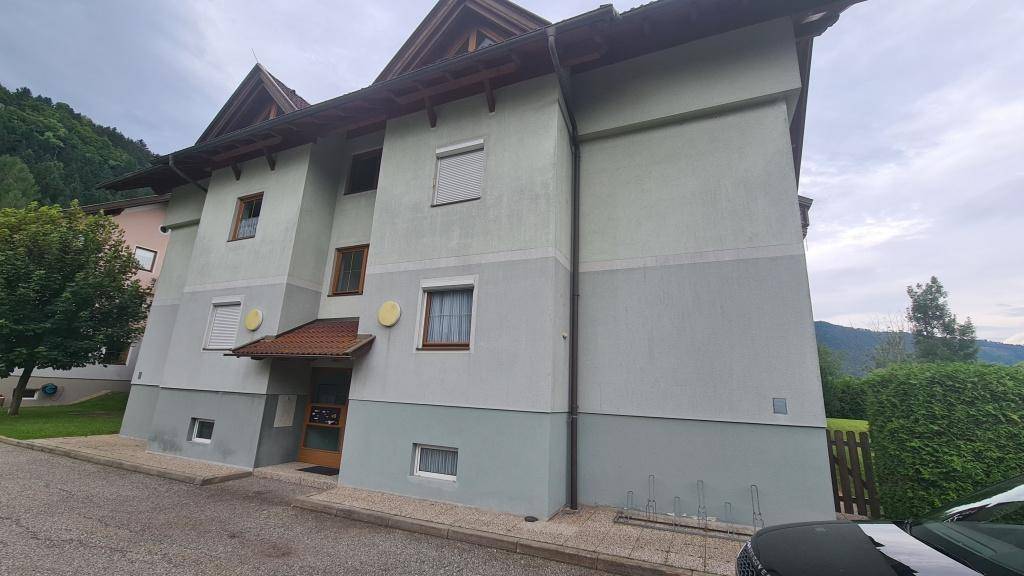 Vorderansicht des Wohnhauses mit Eingangsbereich und Fenstern mit Rollläden.