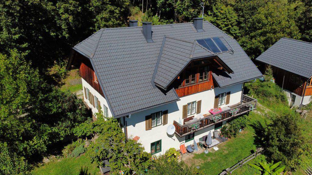 Detailaufnahme des Haupthauses mit Solarpaneelen auf dem Dach und charmanten Balkonen.