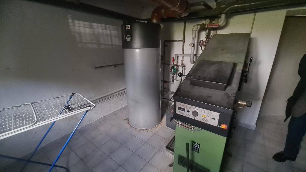 Heizungsraum im Keller mit Boiler, Heizungsanlage und Fliesenboden.