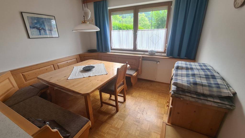 Gemütliche Essecke in der Küche mit Holzbänken und Tisch, ideal für Familienmahlzeiten.