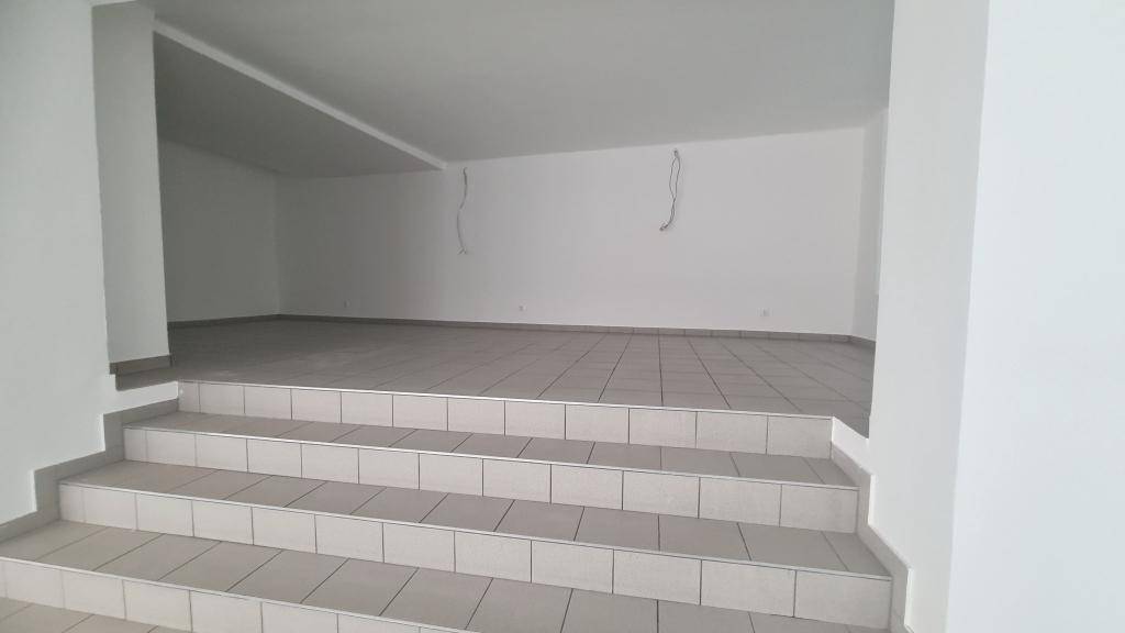 Erhöhter Bereich eines Ladenraums mit Fliesenboden und weißen Wänden, bereit zur individuellen Gestaltung.
