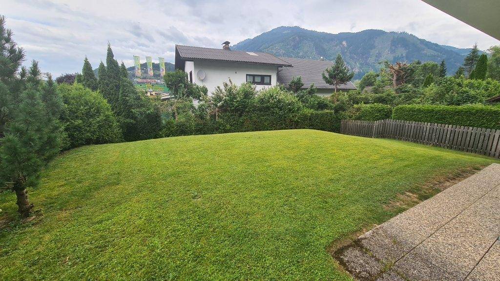 Großer, gepflegter Rasengarten mit weitem Blick auf die beeindruckende Berglandschaft.