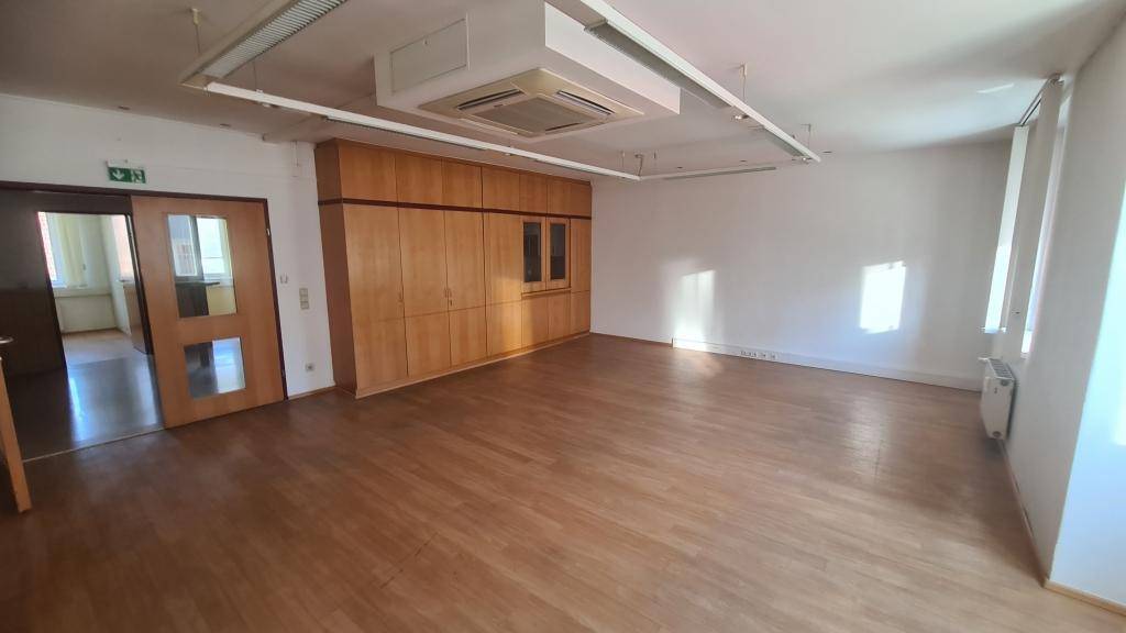 Geräumiges Büro mit Holzboden, Einbauschränken und Klimaanlage, ideal für gewerbliche Nutzung.