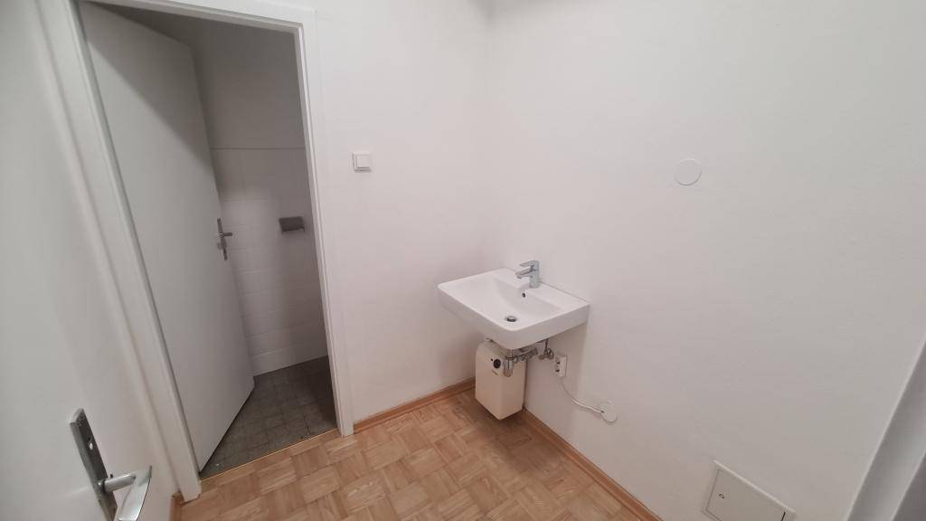 Kleiner Raum mit Waschbecken und Parkettboden, ideal als Gäste-WC oder zusätzliche Waschgelegenheit.