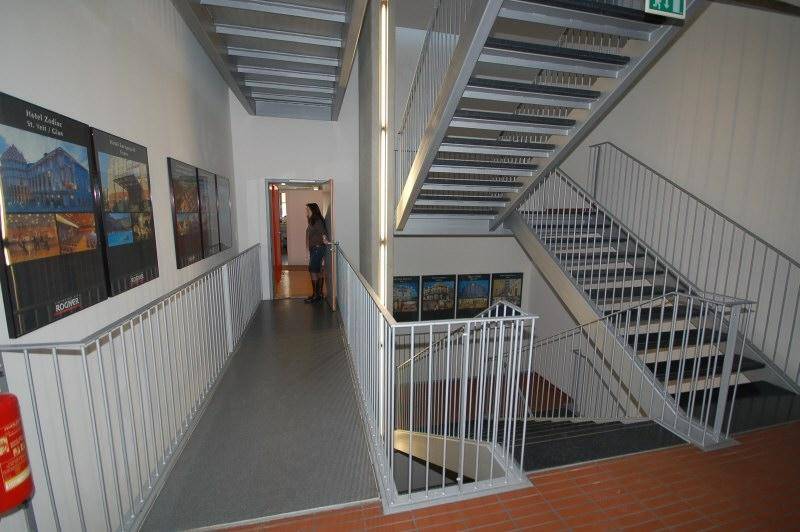 Modernes Treppenhaus mit Metallgeländern und breiten Stufen, das verschiedene Etagen des Gebäudes funktional verbindet.