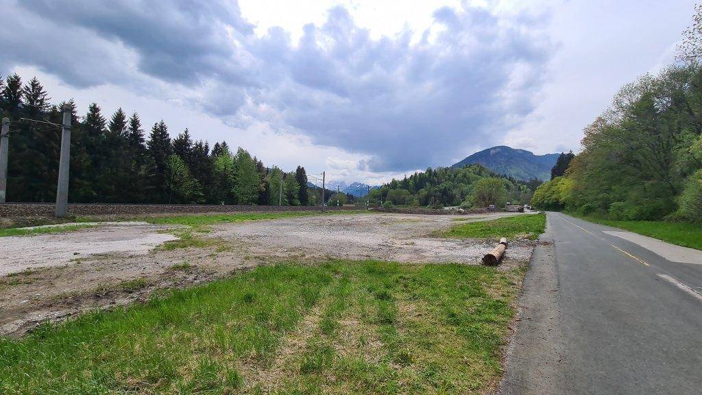 Weitläufiges Grundstück mit Blick auf bewaldete Berge und eine Landstraße.