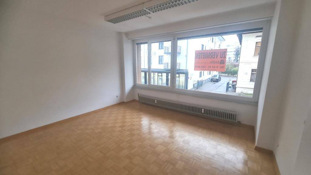 Leerer Büroraum mit viel Tageslicht und Blick auf die umliegenden Gebäude, bietet flexible Nutzungsmöglichkeiten.
