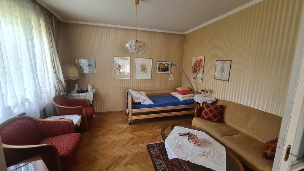 Schlafzimmer mit Parkettboden, Einzelbett und traditionellen Möbeln, hell und freundlich.