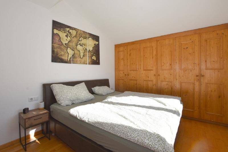 Gemütliches Schlafzimmer mit Doppelbett, Holzboden und integrierten Holzschränken.