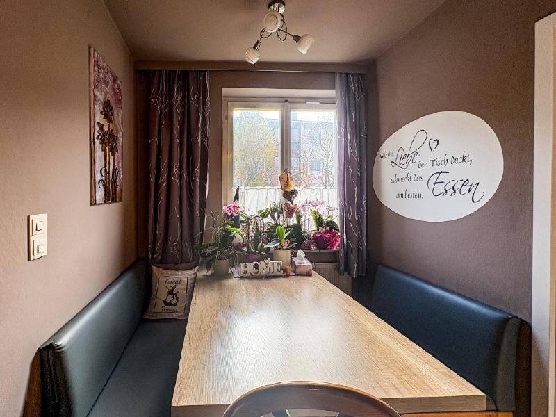 Gemütlicher Essbereich mit Holztisch, Sitzbänken und einem Fenster, das Tageslicht spendet.