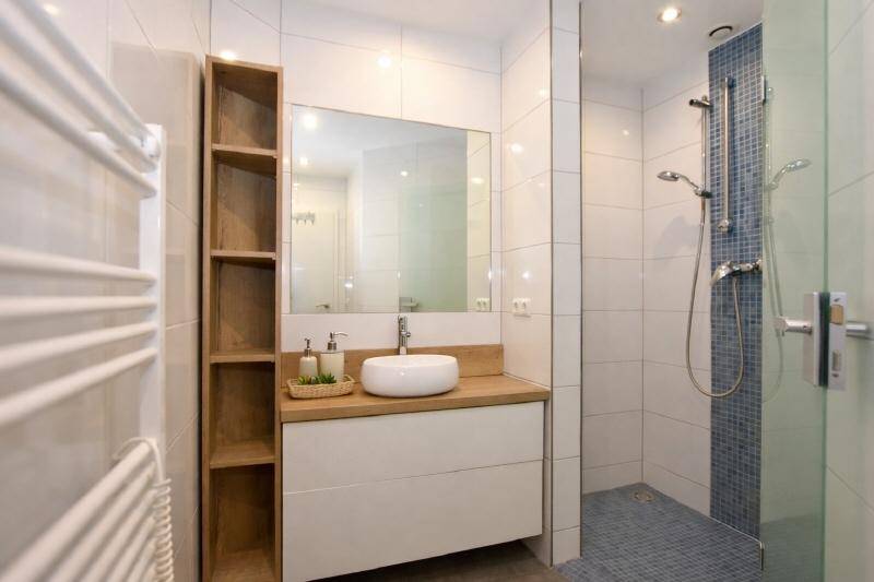 Modernes Badezimmer mit begehbarer Dusche, Einzelwaschbecken und beheiztem Handtuchhalter.