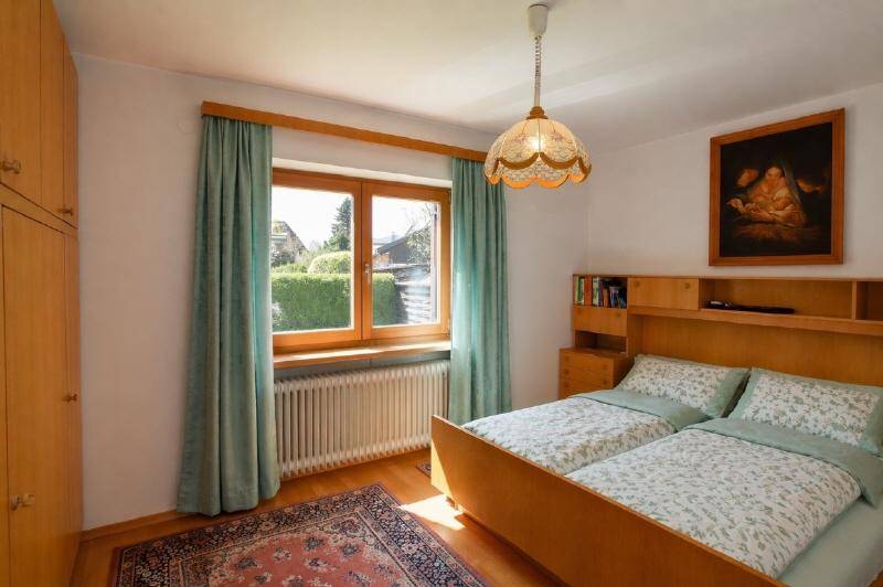 Gemütliches Schlafzimmer mit zwei Einzelbetten, Holzmöbeln und Blick ins Grüne.