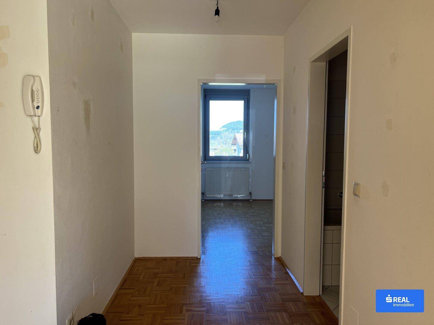 Flur mit Parkettboden und Blick in angrenzende Zimmer.