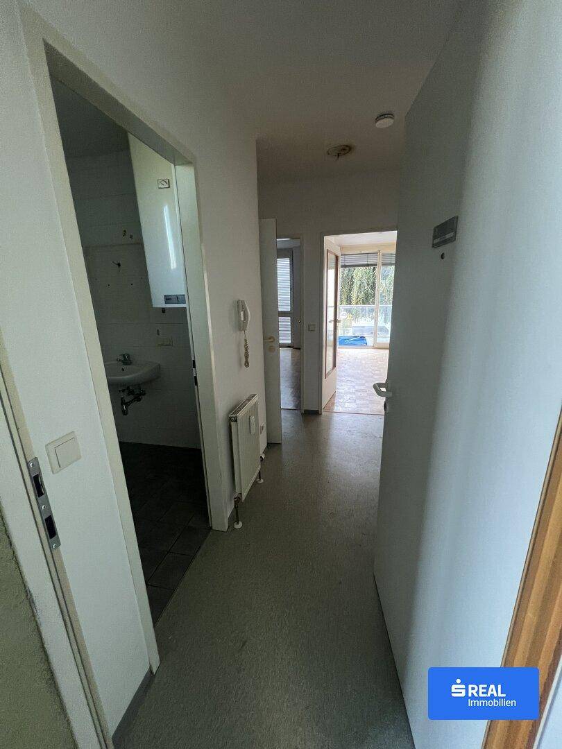 Eingangsbereich einer Wohnung mit Blick in angrenzende Räume und einem Heizkörper an der Wand.