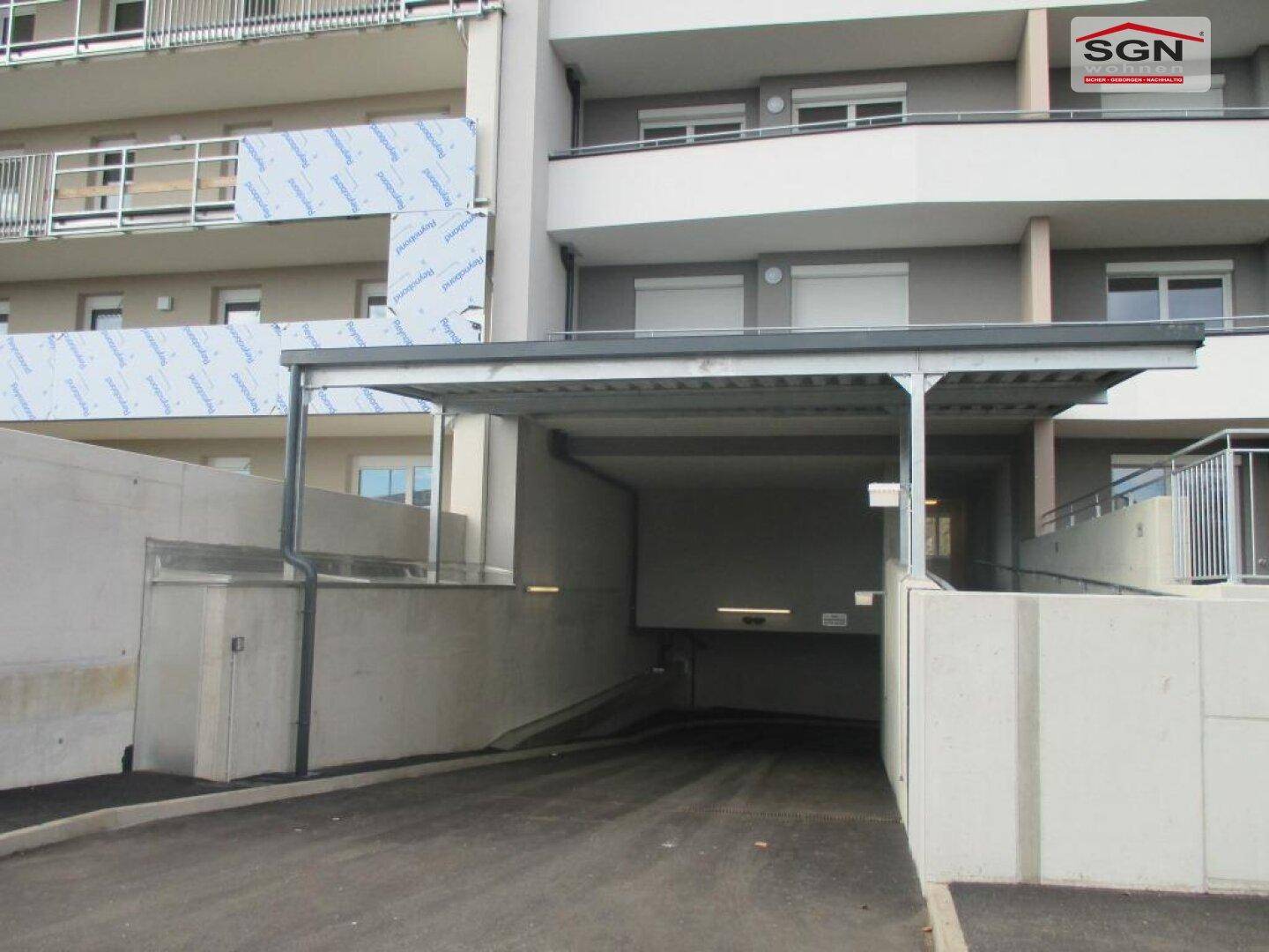 Eingang zur Tiefgarage mit Überdachung und Zufahrtsrampe zum Wohngebäude.