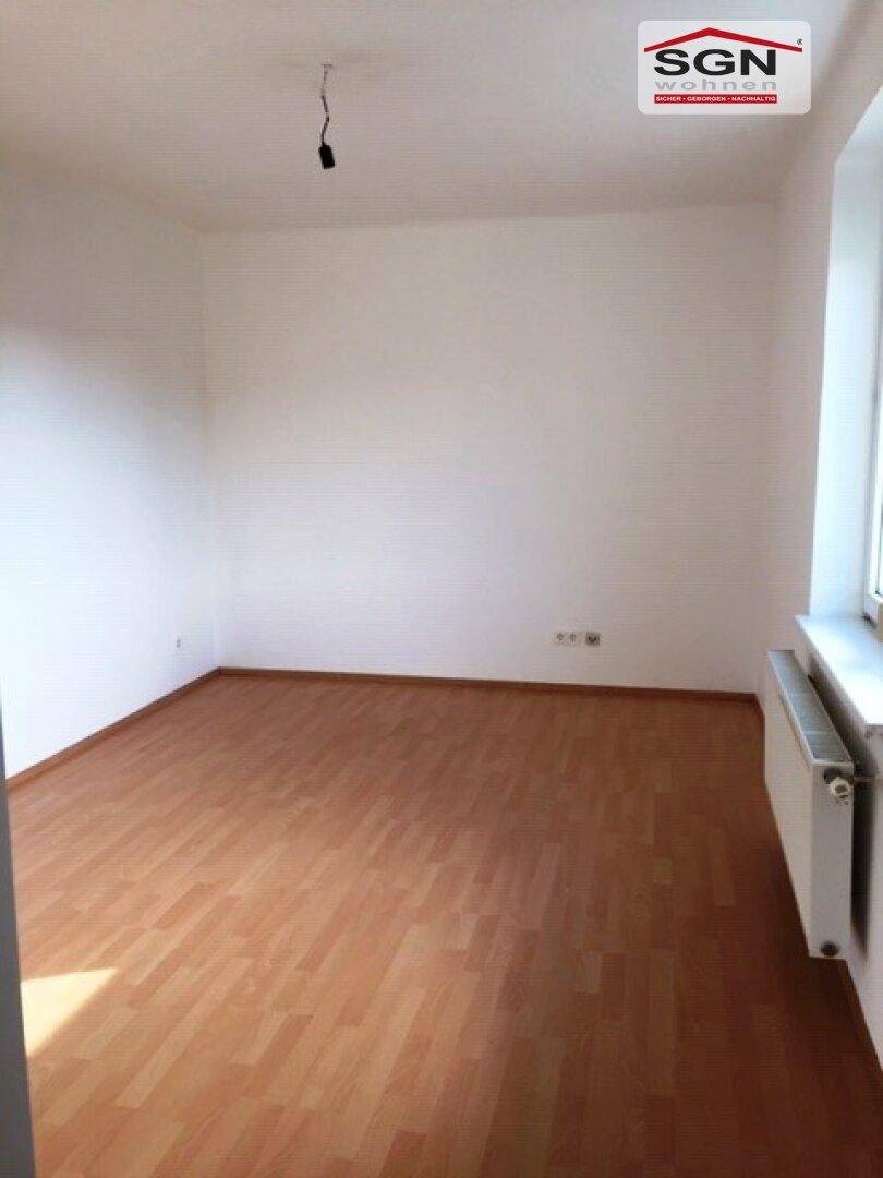 Geräumiger, heller Raum mit Laminatboden und einem Fenster, ideal für verschiedene Einrichtungsideen.