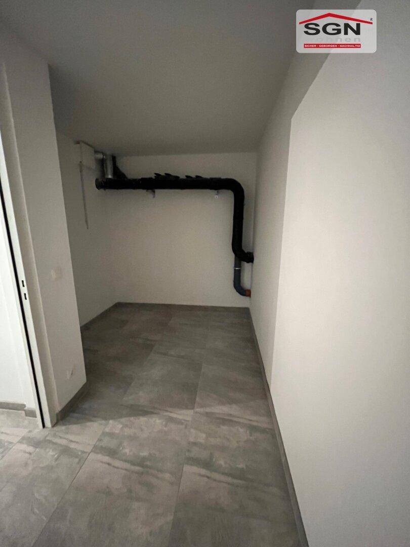 Technikraum mit Fliesenboden und sichtbaren Installationen, ideal für Haustechnik und Lagerung.