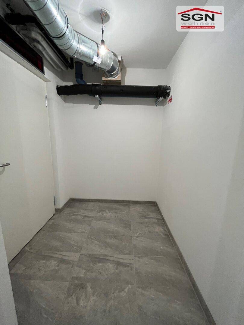 Kleiner Technikraum mit Fliesenboden und sichtbaren Rohren, geeignet für Hauswirtschaft oder Abstellfläche.