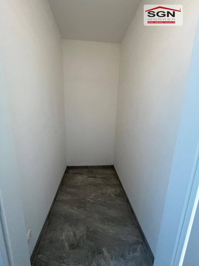 Kleiner Abstellraum mit dunklen Fliesen, ideal für zusätzlichen Stauraum in der Wohnung.