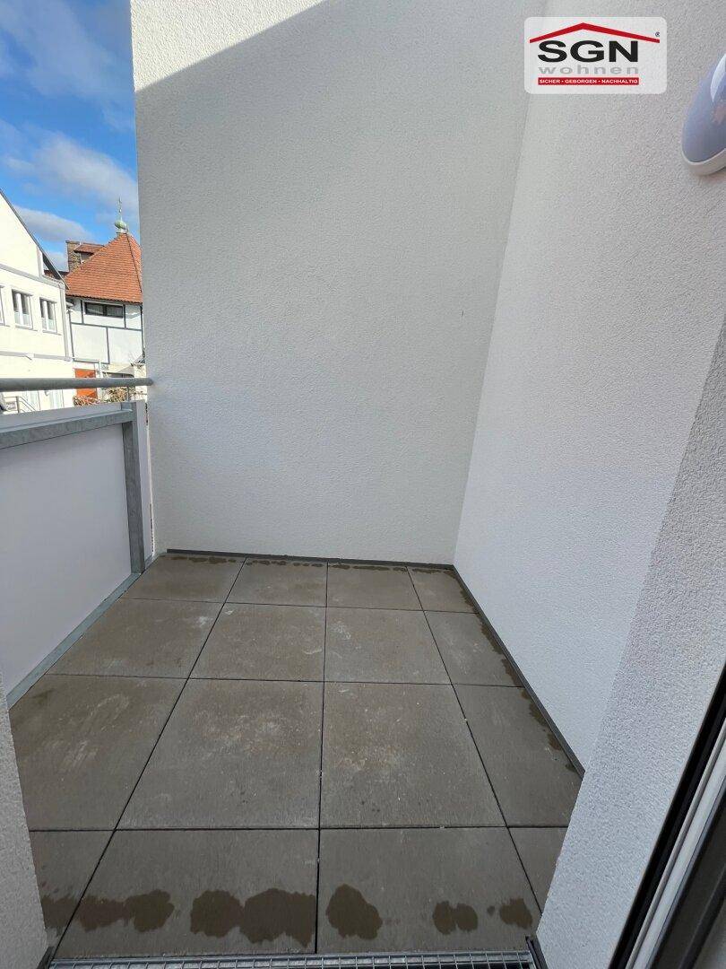 Kleiner, gefliester Balkon mit Blick auf die Nachbarschaft, ideal für entspannte Momente im Freien.