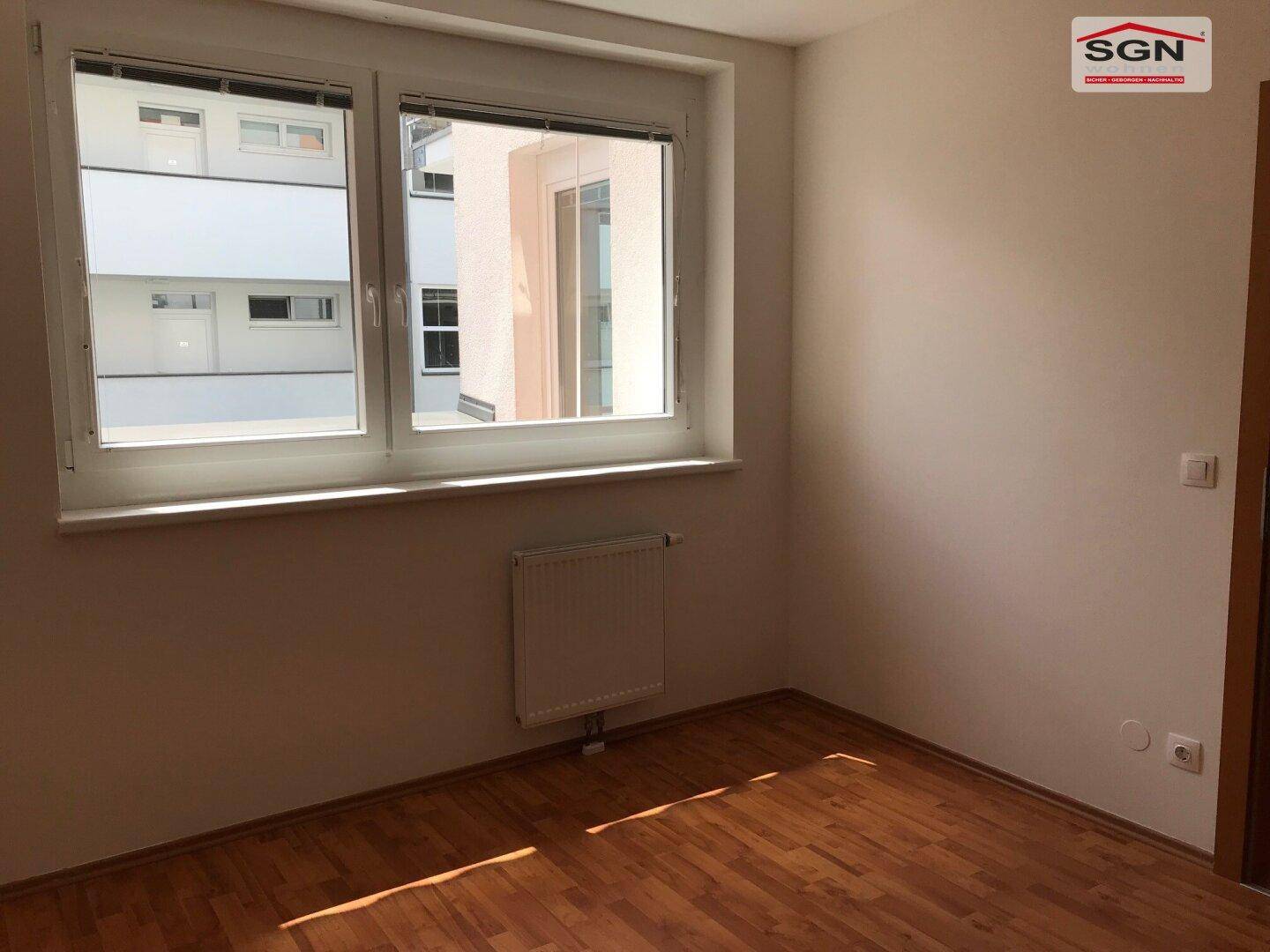 Ruhiges Zimmer mit Laminatboden und Fenster, ideal als Schlaf- oder Arbeitszimmer.