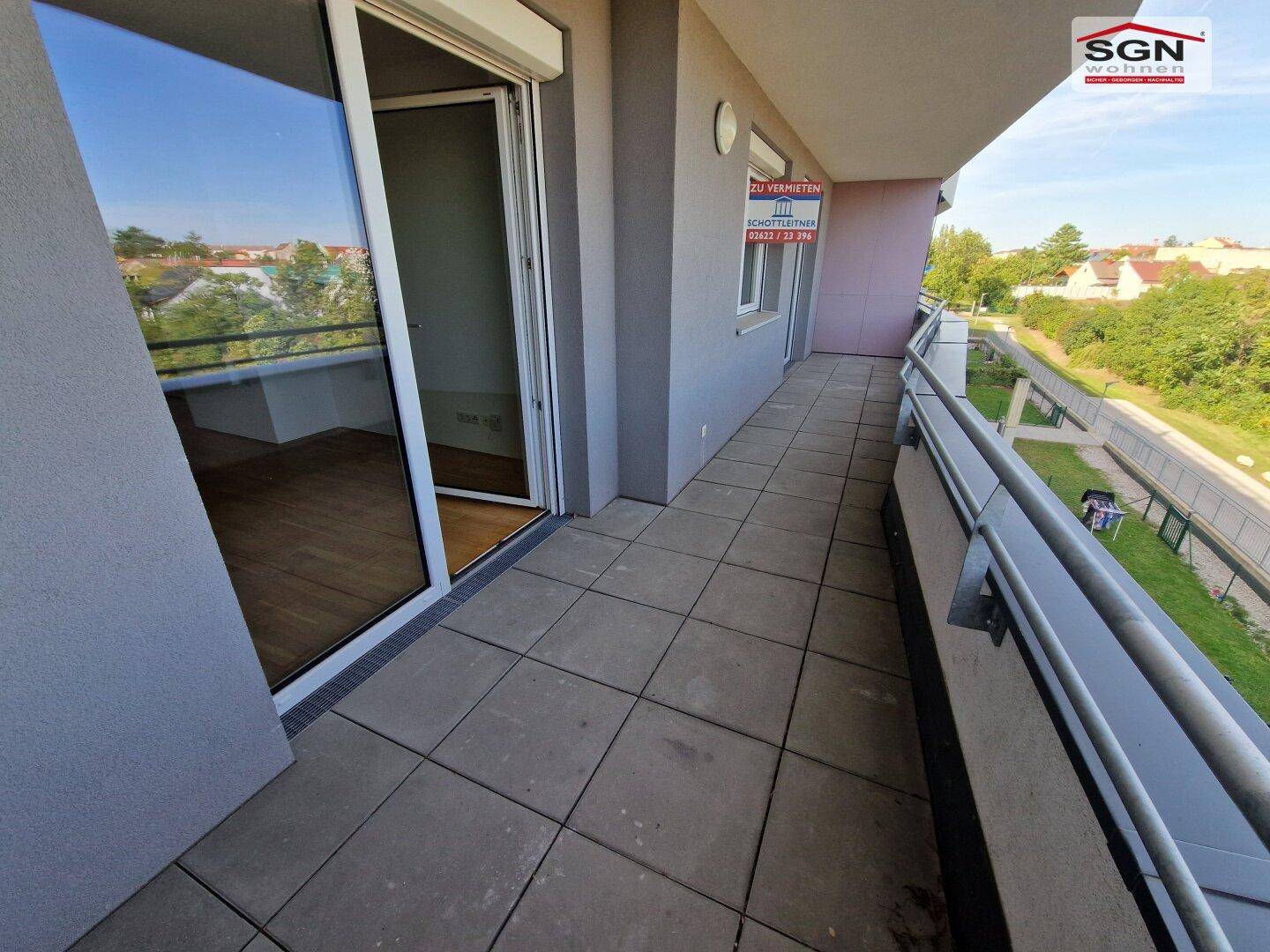 Geräumiger Balkon mit Fliesenboden und Blick ins Grüne, ideal für entspannte Stunden im Freien.