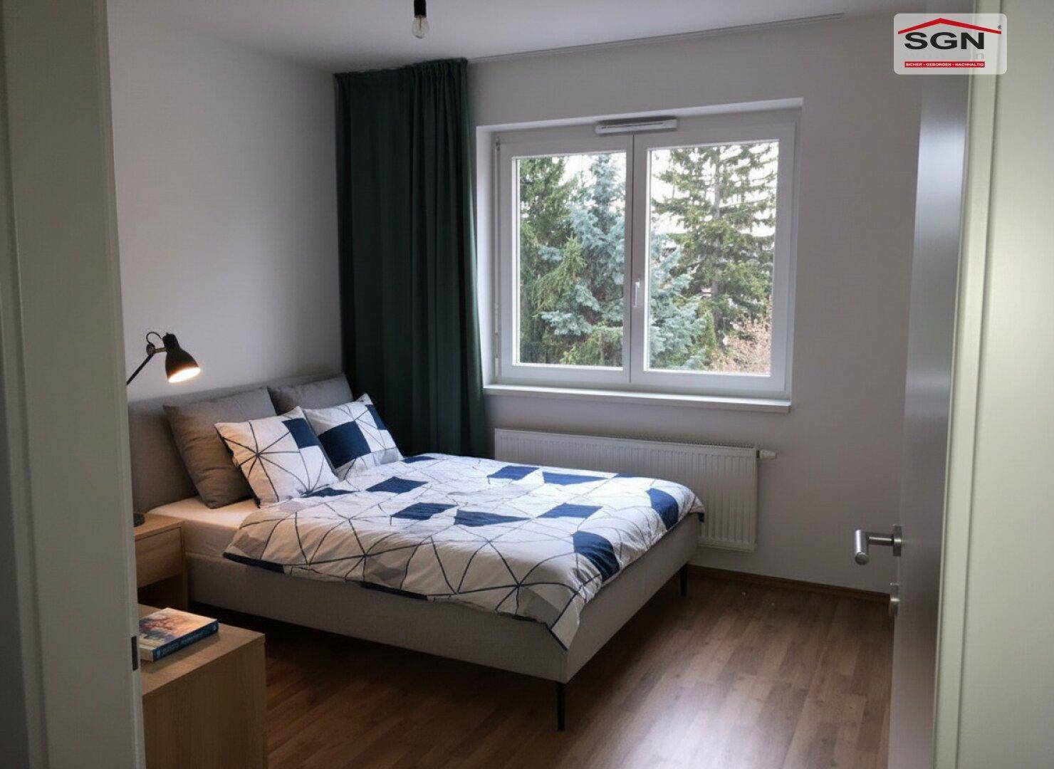 Gemütliches Schlafzimmer mit Holzboden, Doppelbett und Blick ins Grüne.