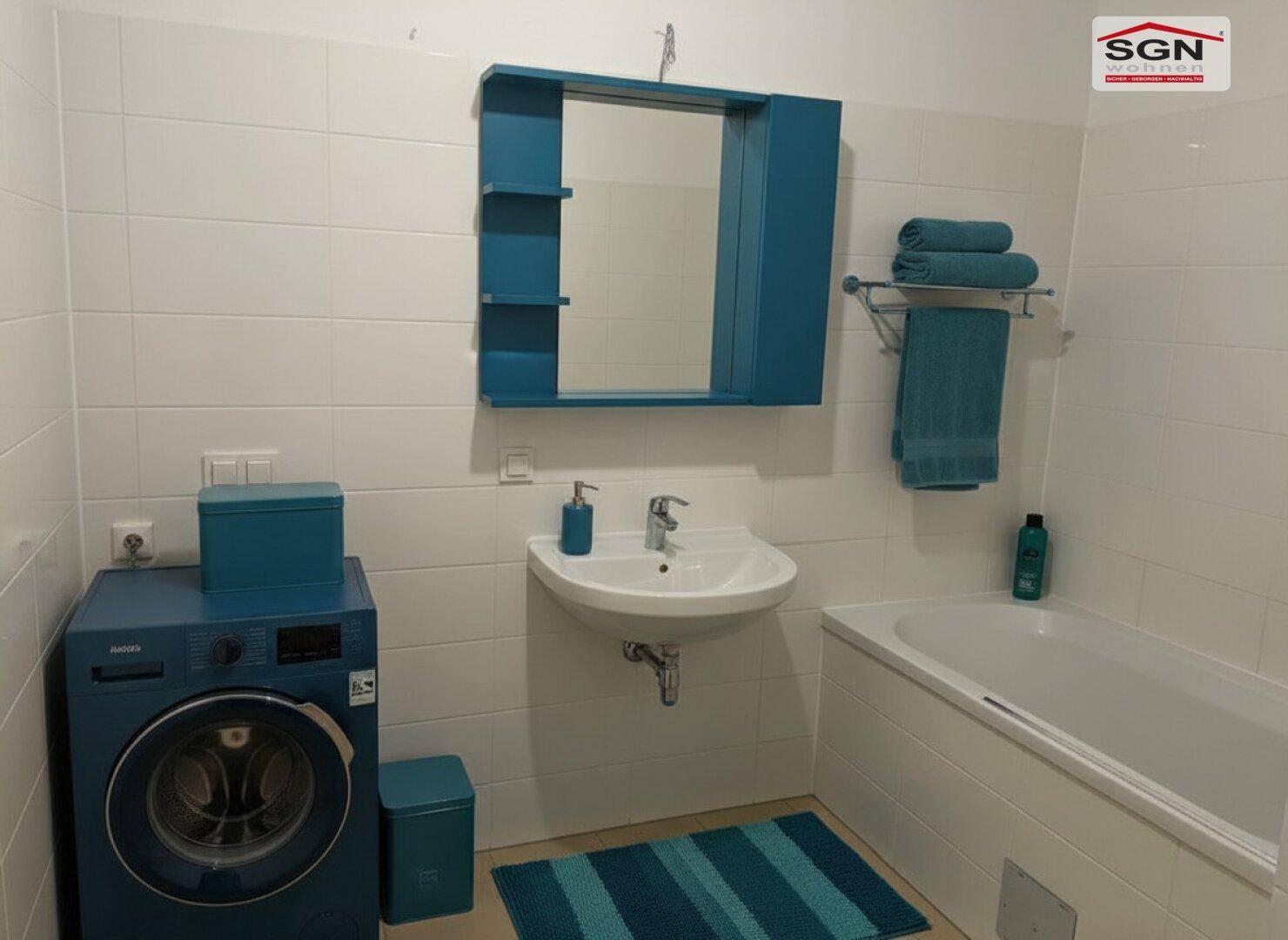 Modernes Badezimmer mit Badewanne, Waschmaschine und blauen Akzenten.