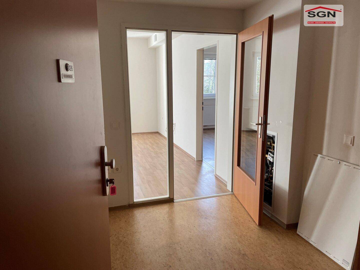 Eingangsbereich mit Korkboden und Holztüren, der zu verschiedenen Zimmern führt.