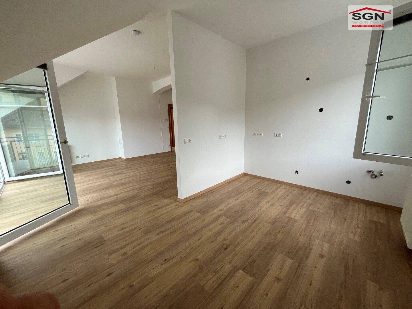 Heller, leerer Raum mit Holzboden und Anschlüssen an der Wand, bereit für die Gestaltung.