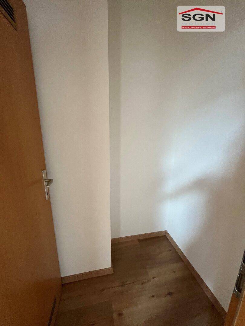 Kleiner, leerer Raum mit Holzboden, ideal als Abstellkammer oder Garderobenbereich.