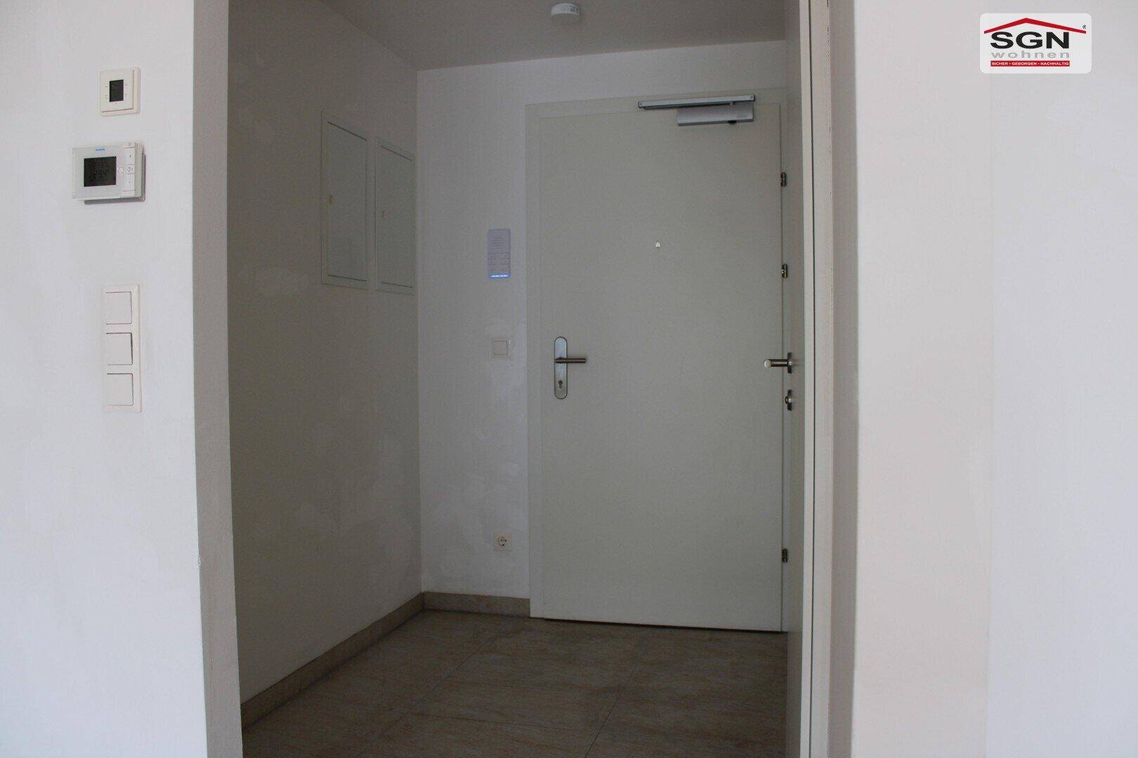 Eingangsbereich mit Sicherheitstür und Fliesenboden, bietet Zugang zur Wohnung.