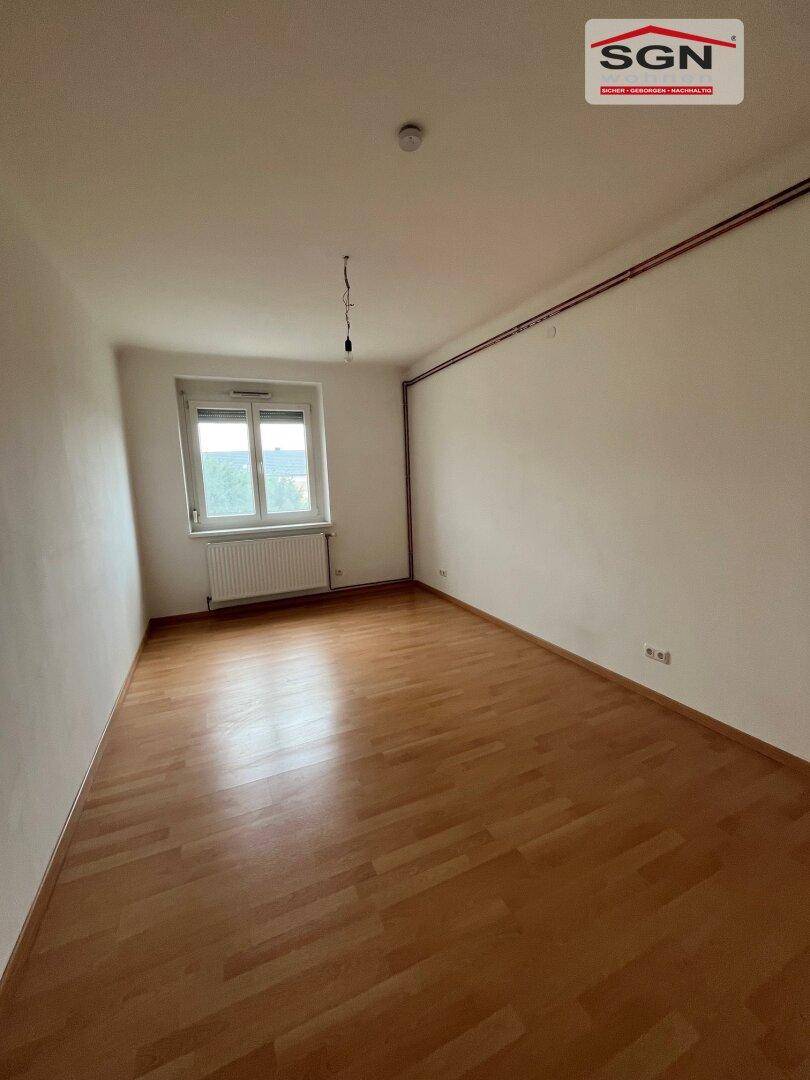 Geräumiges, helles Zimmer mit Laminatboden und Fenster, ideal als Schlaf- oder Arbeitszimmer.