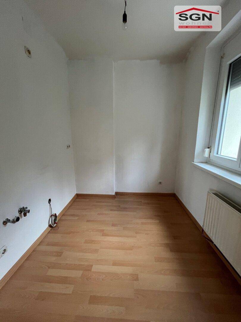 Kleiner, heller Raum mit Laminatboden und sichtbaren Anschlüssen, vielseitig nutzbar.