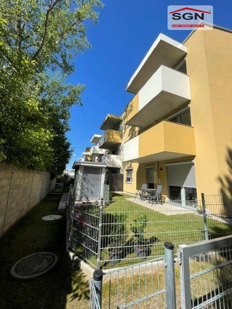 Kleiner privater Gartenbereich mit Terrasse und Sitzgelegenheiten, umgeben von einem Zaun.