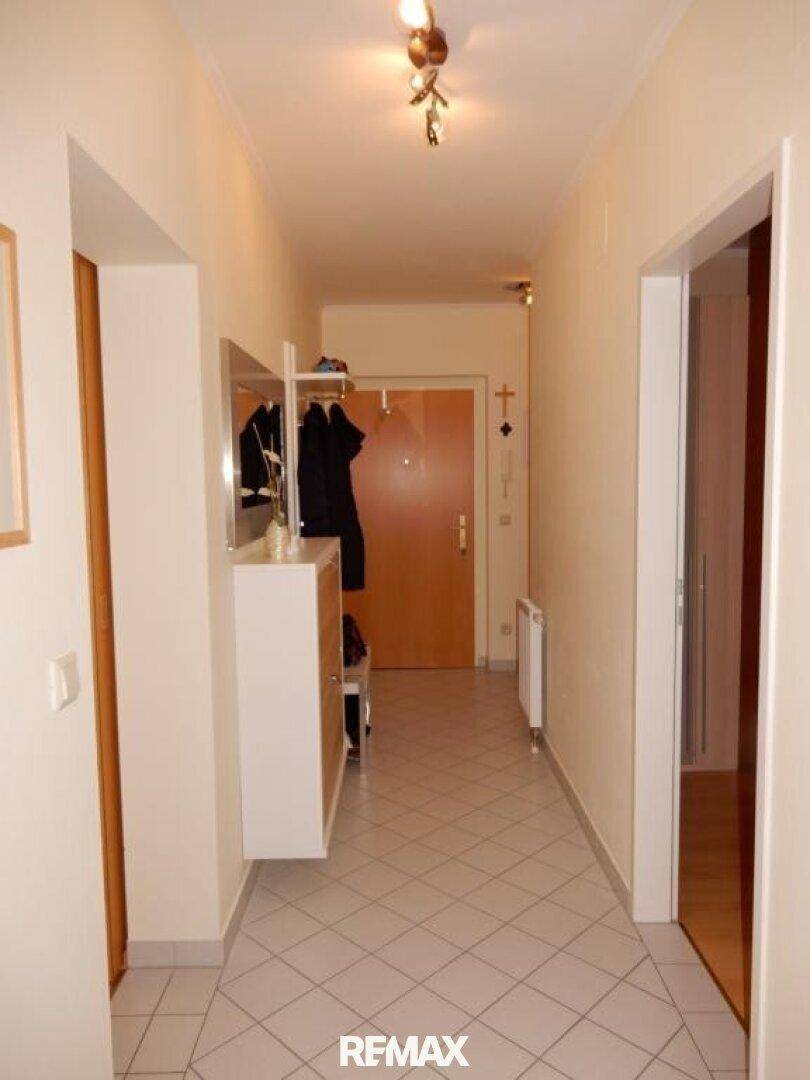 Heller Flur mit Fliesenboden, Garderobe und Zugang zu weiteren Räumen der Wohnung.
