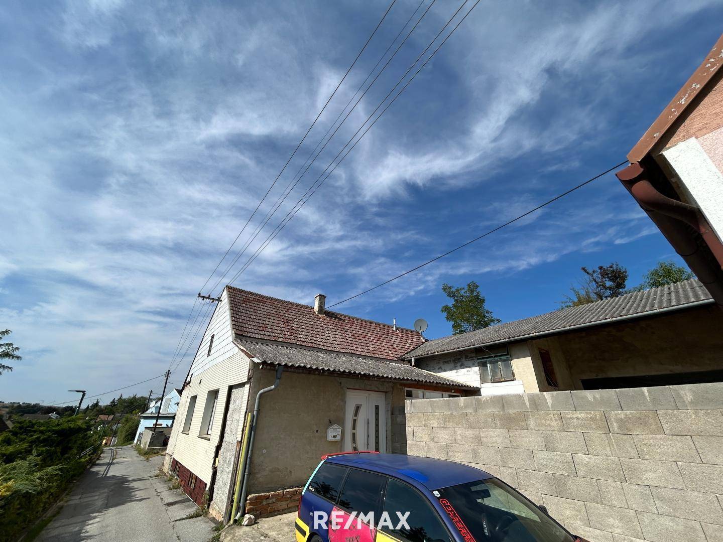 Vorderansicht eines älteren Hauses mit Satteldach und einfacher Eingangstür.