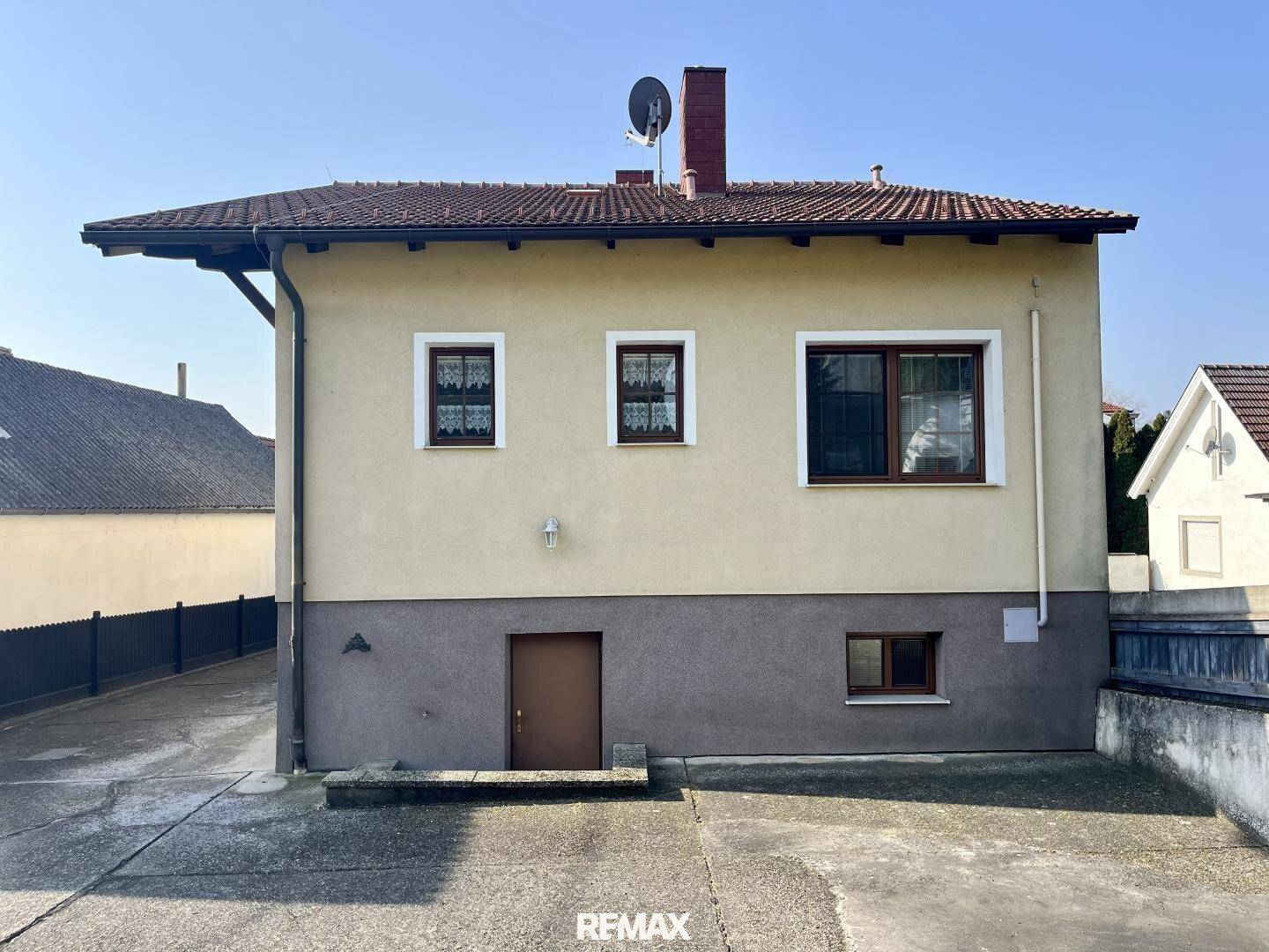 Rückseite des Hauses mit Zufahrt und separatem Eingang zum Keller.