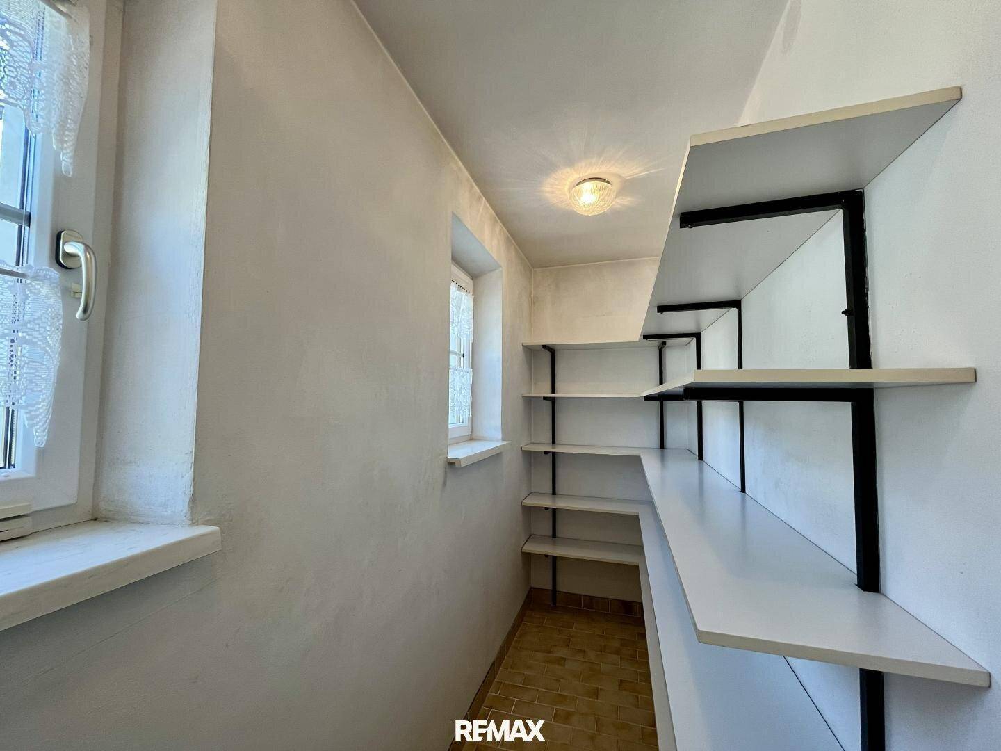 Praktische Speisekammer mit Regalsystem und kleinem Fenster für Belüftung.