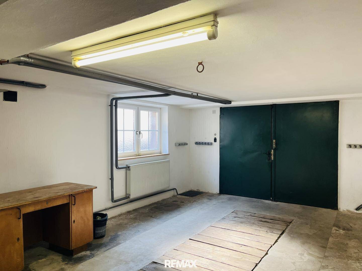 Geräumige Garage mit Werkbank, Fenster und direktem Zugang zum Haus.
