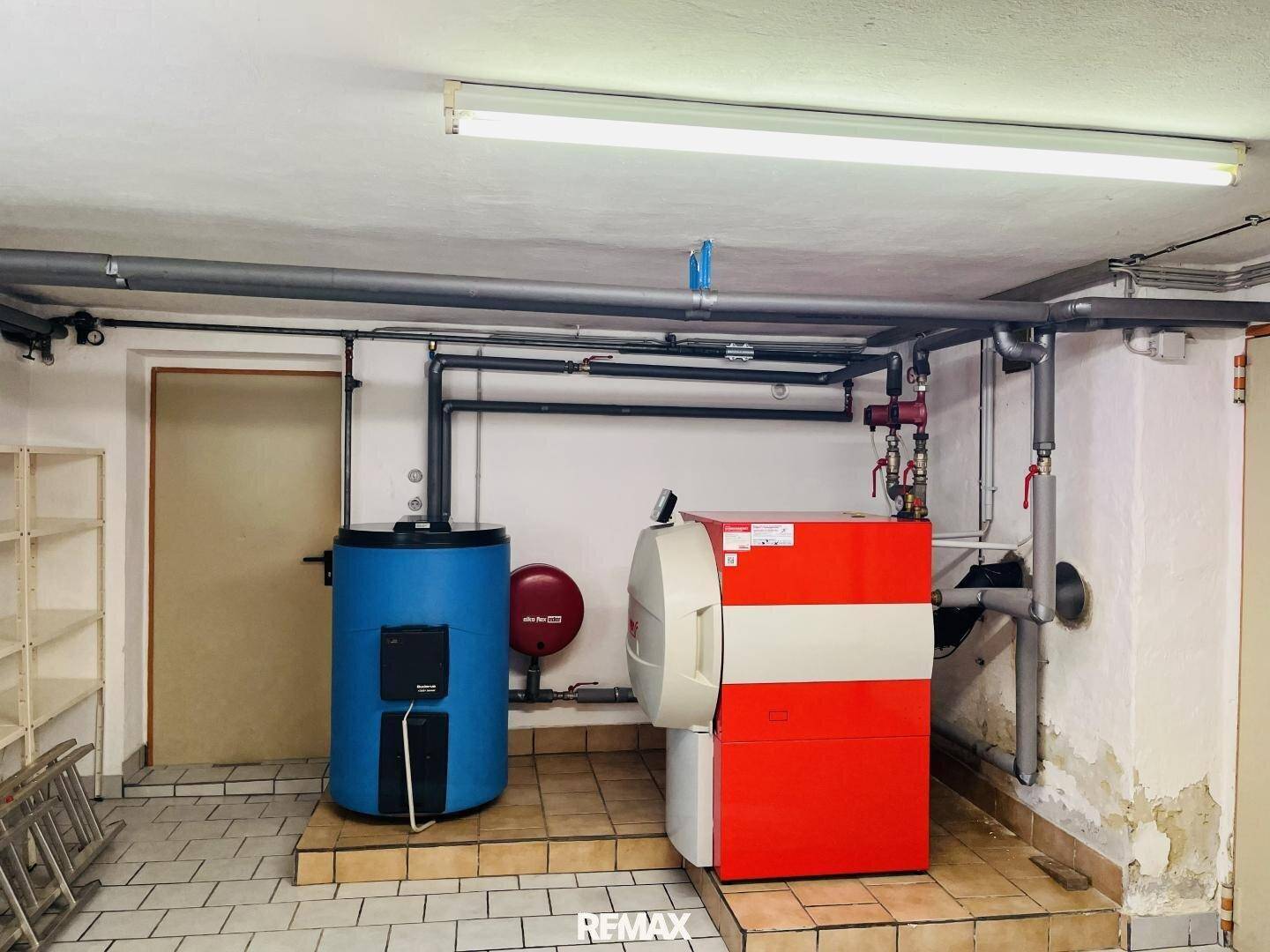 Heizungsraum im Keller mit moderner Heizungsanlage und Warmwasserspeicher.