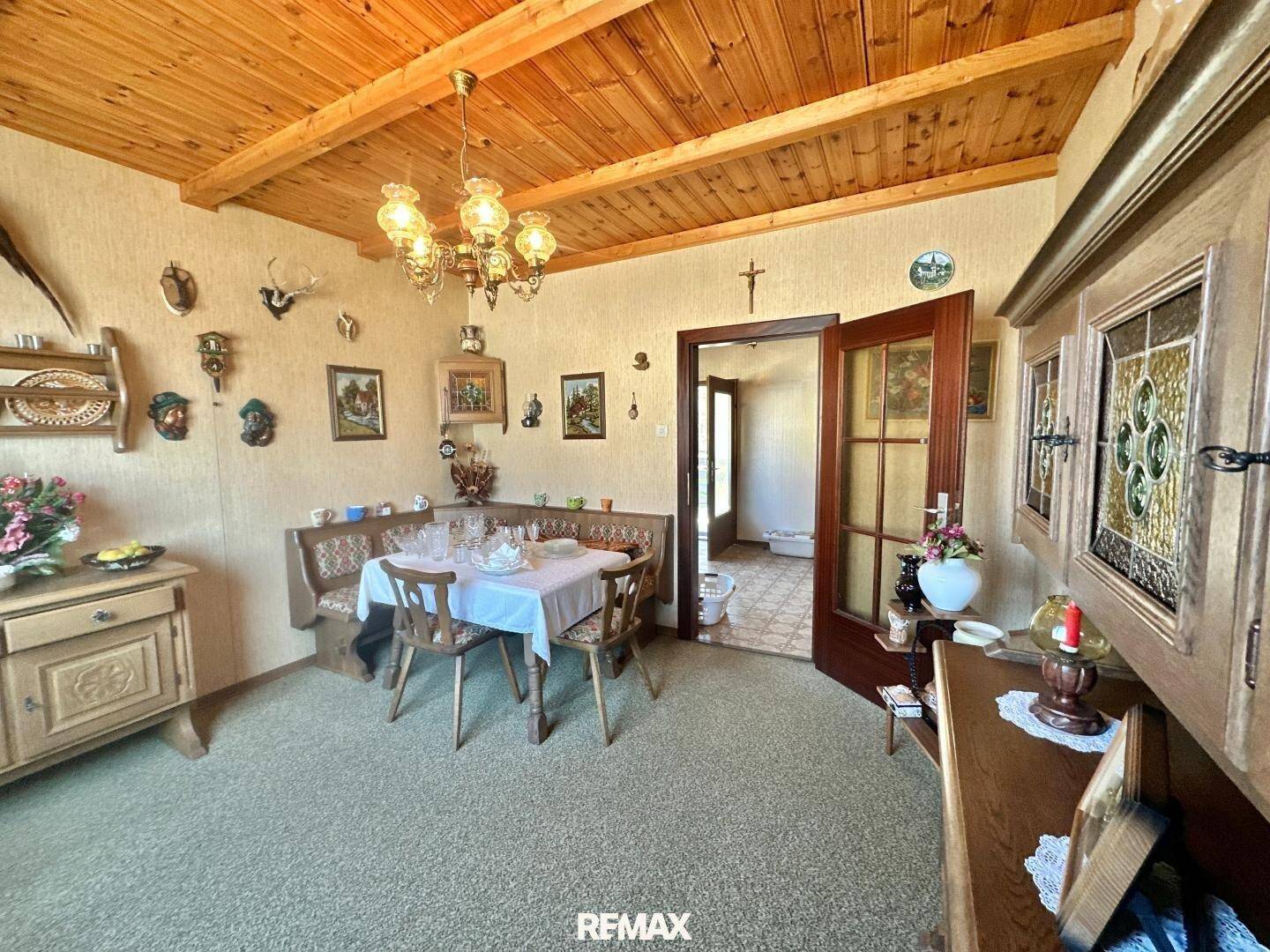 Traditionelles Esszimmer mit Eckbank, Holztisch und rustikaler Holzdecke.