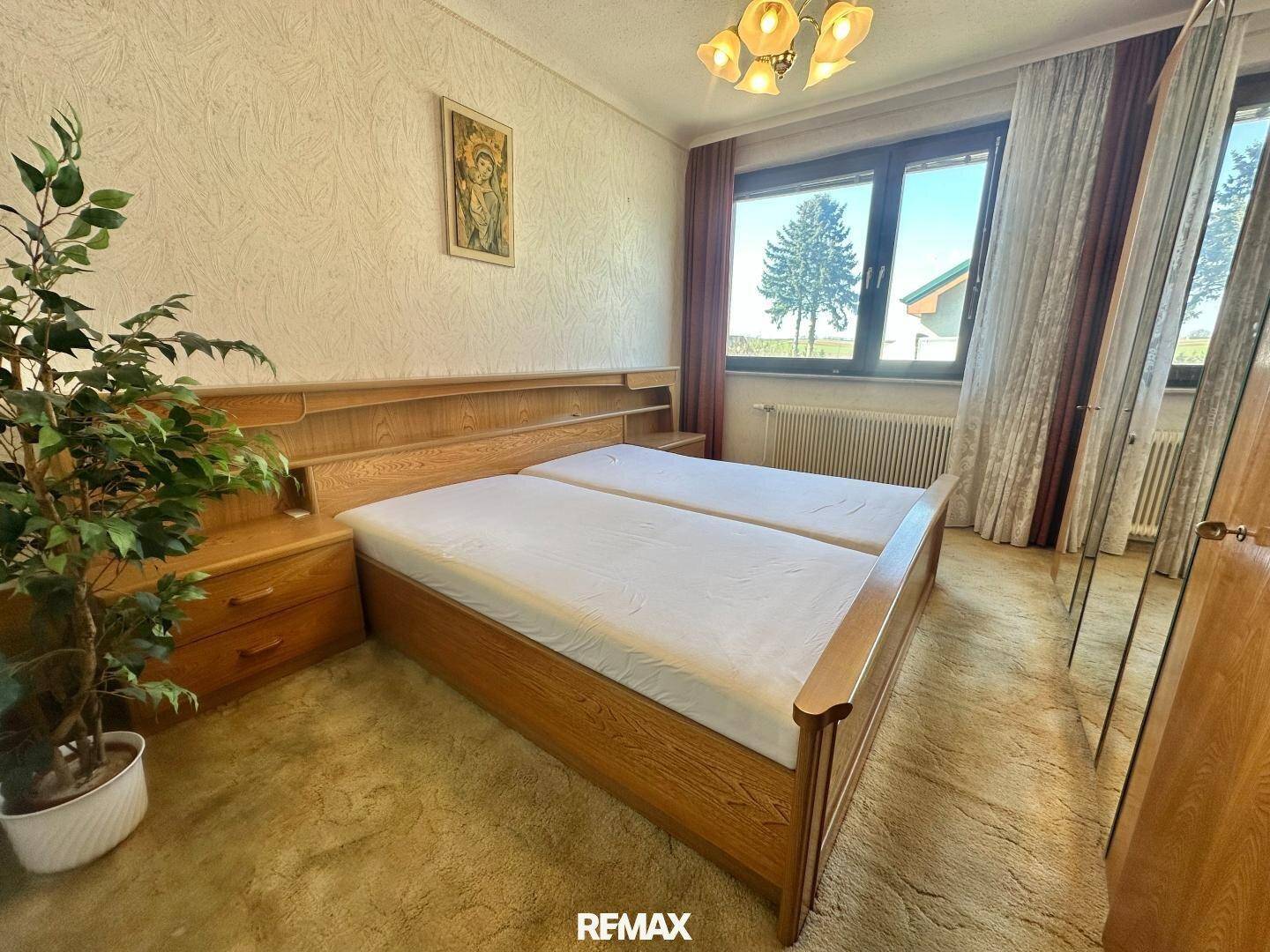 Gemütliches Schlafzimmer mit zwei Einzelbetten, Holzmöbeln und Teppichboden.